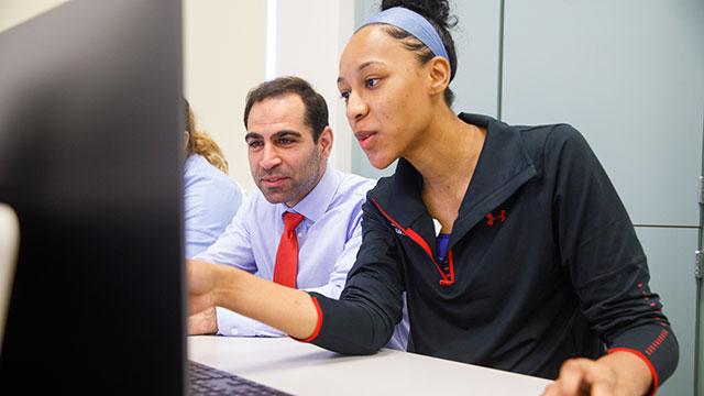 Student and professor looking at a computer screen.